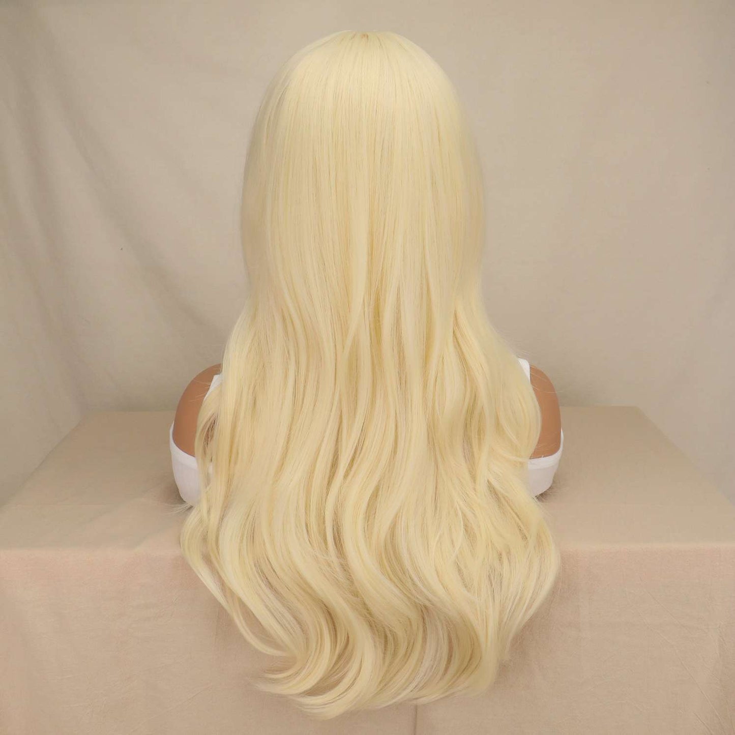 Woman wearing long blonde straight wig with soft waves and natural movement