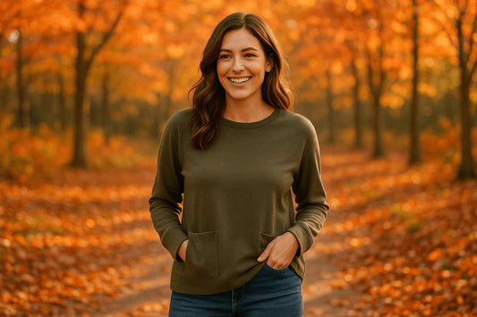 Woman wearing olive green casual pocket top and jeans in autumn forest with orange leaves