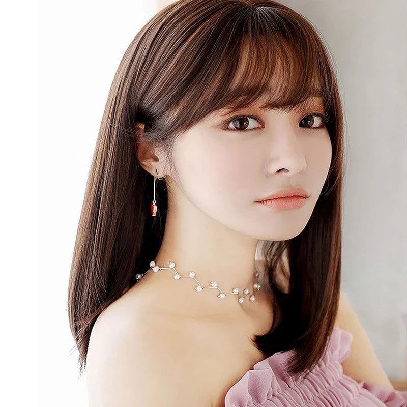 Warm brown straight synthetic wig with reddish highlights, styled with accessories to demonstrate versatile heat-styling capabilities up to 150°C
